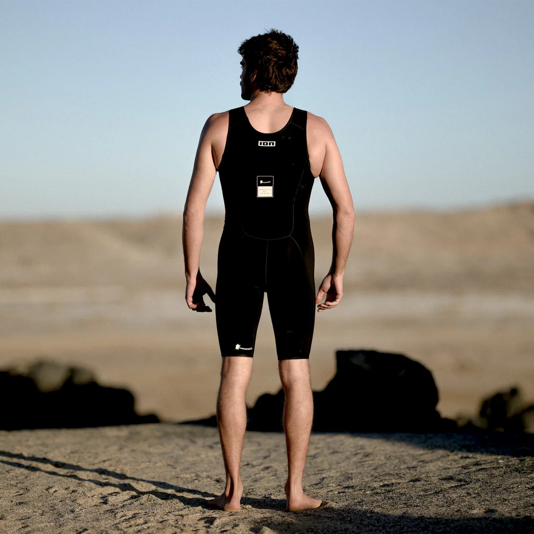 Man in ION Monoshorty 0.5 herenwetsuit zwart aan de kust